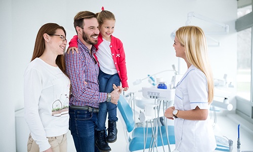 Dentist talking to family at dental appointment