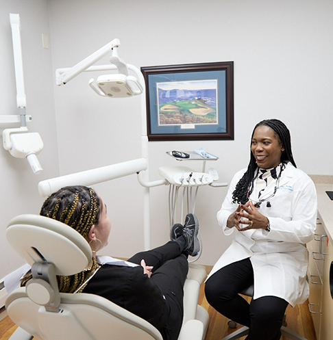 Doctor Matthews talking with a patient in the dental chair