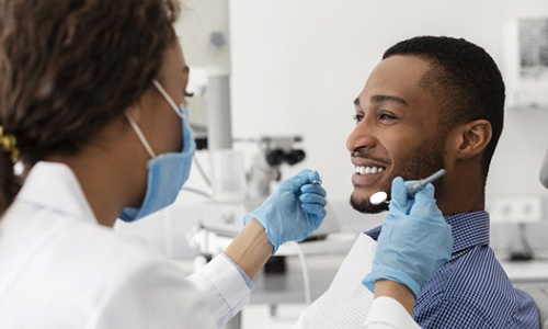 Man smiles after getting a dental bridge in Worcester