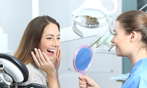 Woman admiring her new dental crown in Worcester