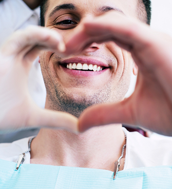 Dental patient making a heart shape with his hands