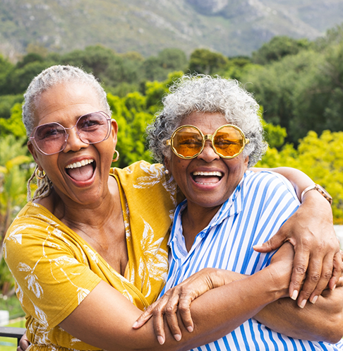Two older women laughing together outdoors