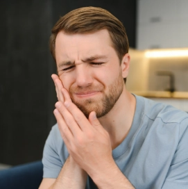 Young man holding the side of his face in pain