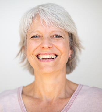 Senior woman smiling in a pale pink blouse