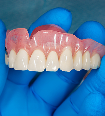 Dentist holding a full denture