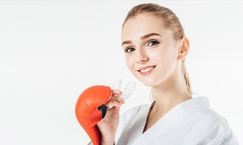 Teen girl with boxing gloves holding mouthguard