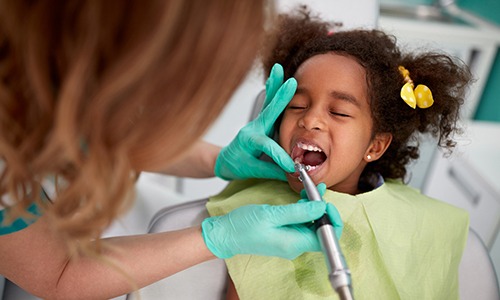 Dentist cleaning child's teeth