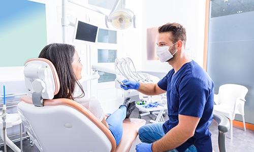 Family dentist talking to adult patient