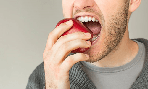 a closeup of someone biting an apple
