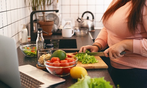Closeup of woman making salad at home