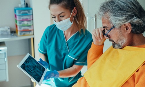 Patient and dental assistant reviewing X-ray at office