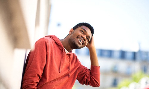 person smiling and running their hand through their hair