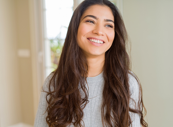 Young woman with long dark brown hair smiling