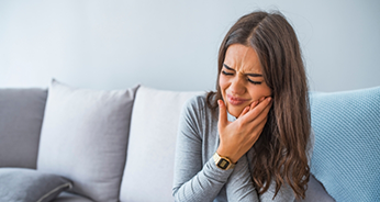 Woman holding the side of her face in pain