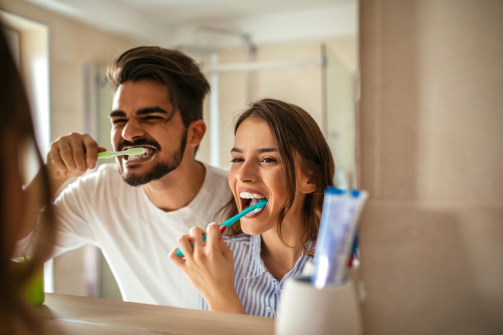 Man and woman brushing their teeth with tips from the dentist in Worcester