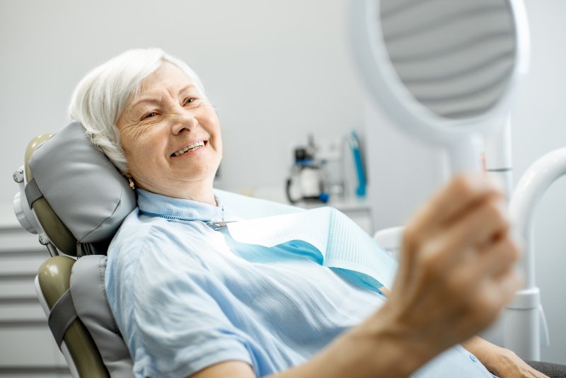 Elderly woman smiling with dental implants