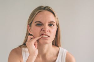 woman poking her gums wondering if gums grow back