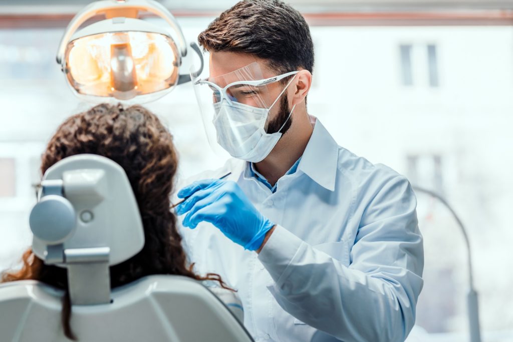 Dentist cleaning patient's teeth and gums