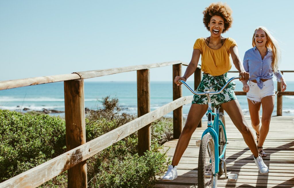 Friends smiling on a boardwalk on a sunny day