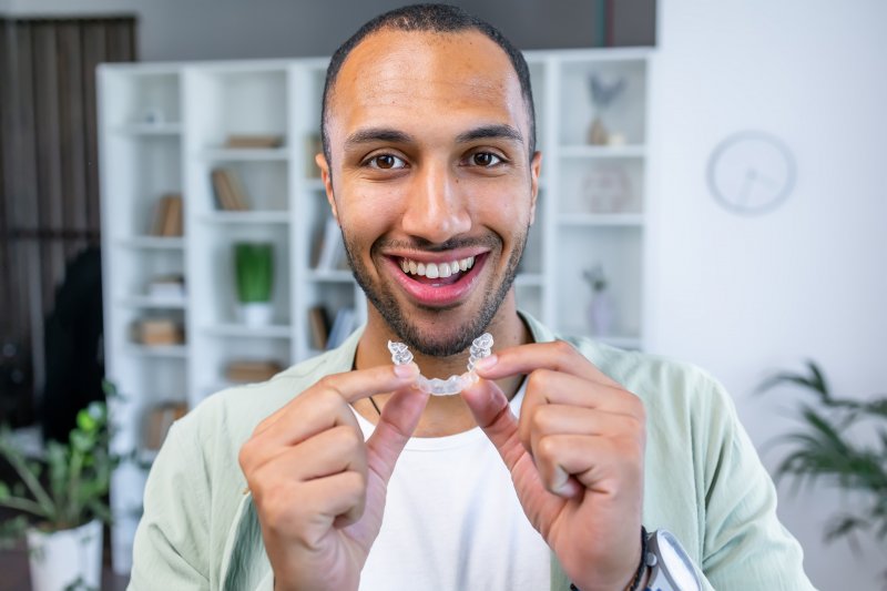 man holding Invisalign aligners
