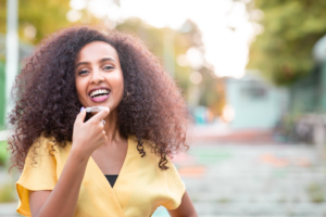 a patient with Invisalign smiling while traveling